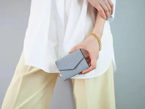 ボナベンチュラの三つ折り財布を持つ女性