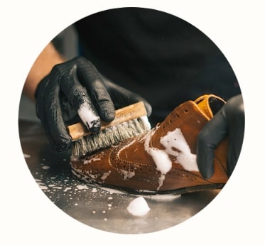 革靴をブラシで洗う職人の手