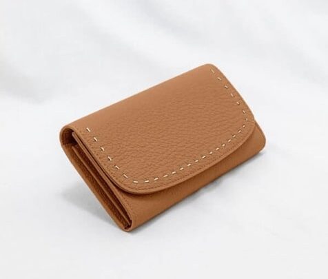 手縫いで仕上げる革紐ステッチが特徴的なキャメルのかぶせ式長財布