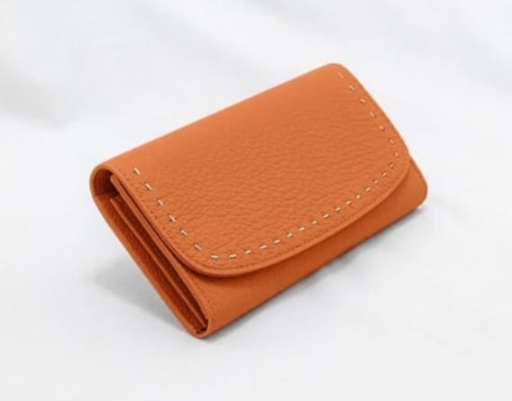 エスポワールの高級感と手縫いの革紐ステッチが特徴的なオレンジのかぶせ式財布